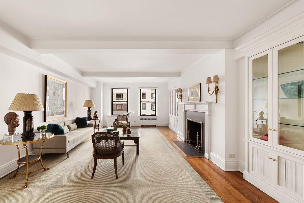 47 East 88th Street, Unit 8A Manhattan, NY 10128 - Photo 2 of 27 a living room with furniture a fireplace and a large window