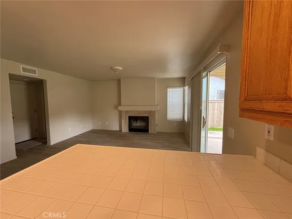 a view of an empty room with a fireplace and a window