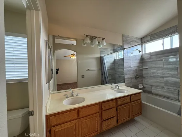 a bathroom with a double vanity sink large mirror and a bathtub