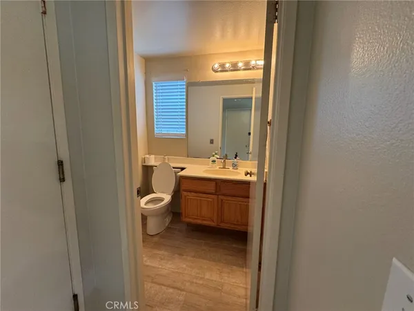 a bathroom with a granite countertop toilet a sink and a mirror