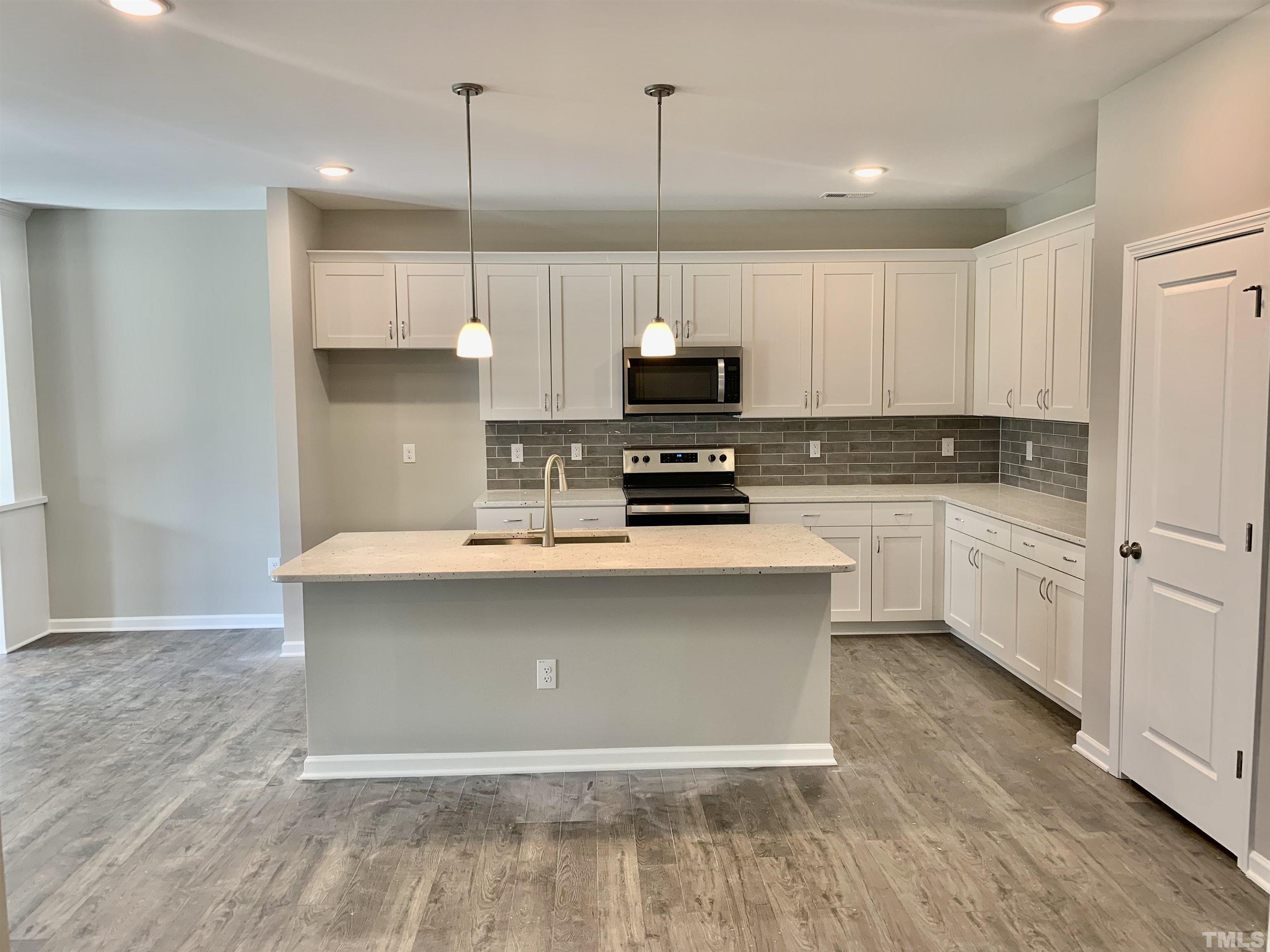106 Two Daughters Streme Smithfield, NC 27577 - Photo 3 of 14 a kitchen with kitchen island a counter top space a sink and cabinets