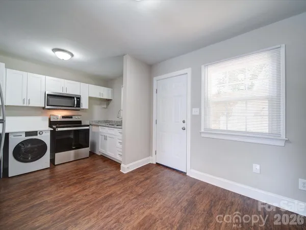 a kitchen with granite countertop a refrigerator and a stove top oven