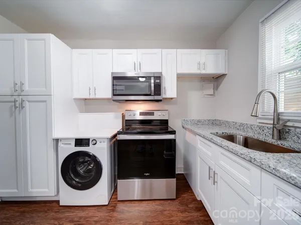 a kitchen with sink a stove and cabinets