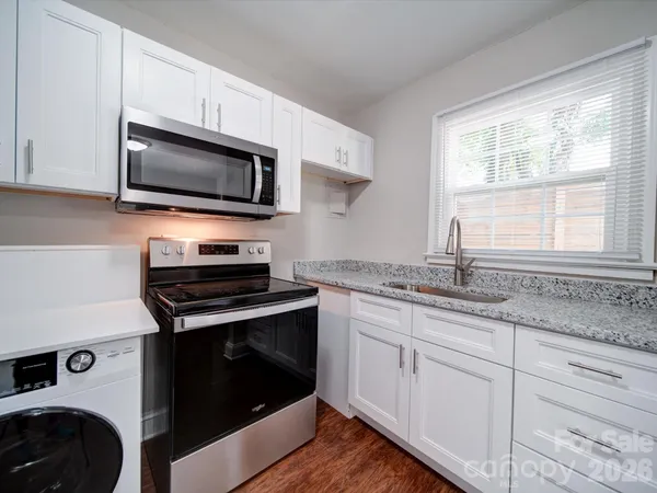 a kitchen with granite countertop cabinets stainless steel appliances and a window
