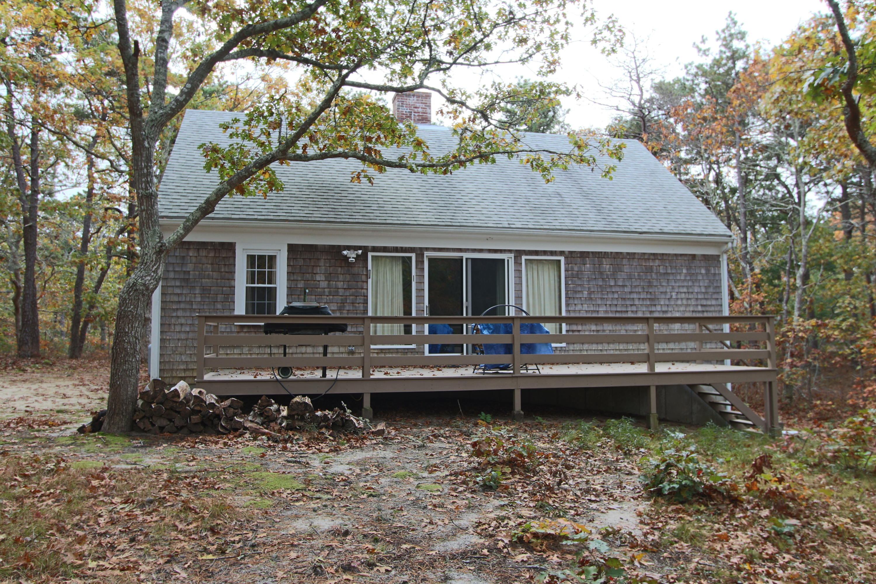285 Long Pond Road Wellfleet, MA 02667 - Photo 21 of 28 a backyard of a house with barbeque oven table and chairs