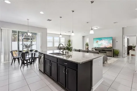 a kitchen with granite countertop stainless steel appliances a sink dishwasher a refrigerator a stove top oven and granite countertops