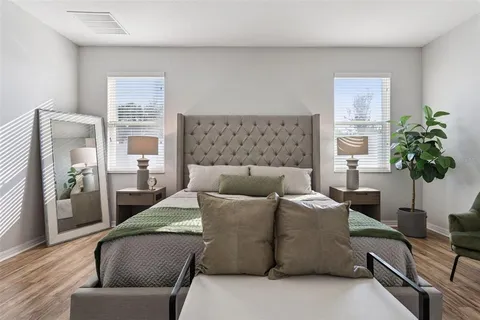 a bedroom with a bed table and chair