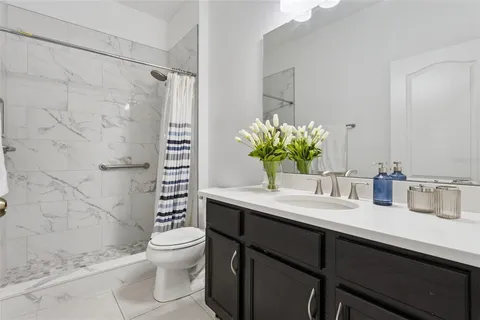 a bathroom with a granite countertop sink a large mirror and a wooden floor