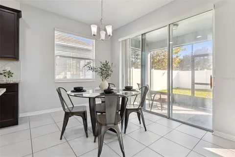 a kitchen with stainless steel appliances granite countertop a table chairs sink and cabinets