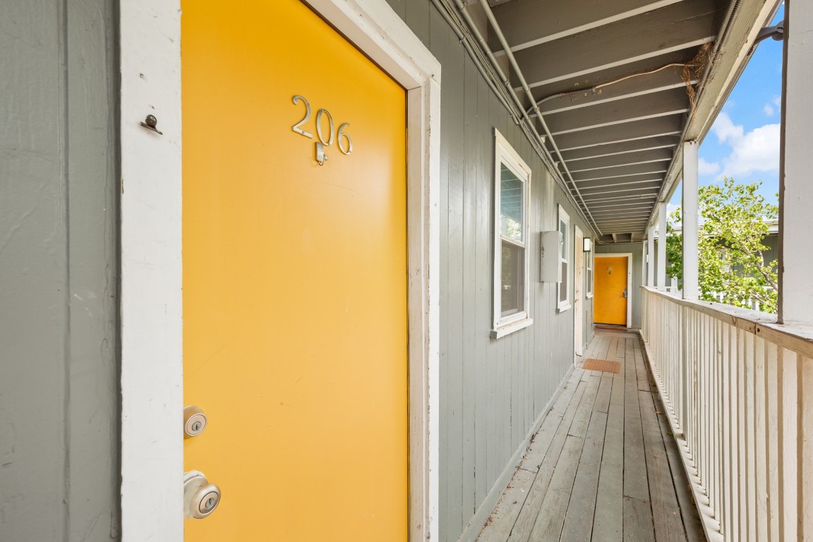 2401 Manor Road, Unit 206 Austin, TX 78722 - Photo 13 of 17 a view of a hallway with wooden floor and a bathroom
