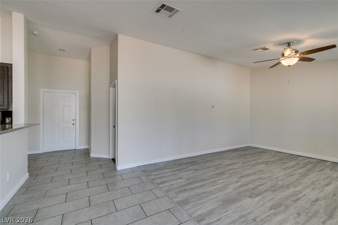 2028 Rustler Ridge Avenue North Las Vegas, NV 89031 - Photo 9 of 40 A versatile living space boasts a blend of sleek tile and elegant wood flooring, perfect for modern living.
