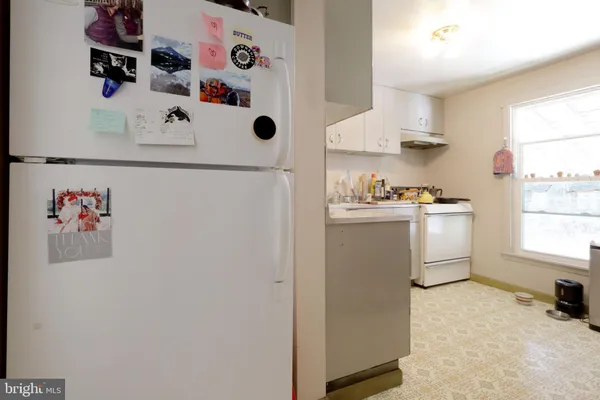 a kitchen with a refrigerator a sink and wooden floor
