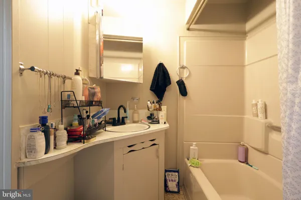 a bathroom with a tub sink and mirror