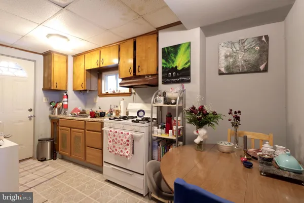 a kitchen with a table chairs stove and cabinets