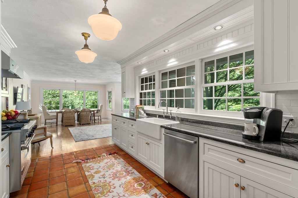 593 Peakham Road Sudbury, MA 01776 - Photo 14 of 42 a kitchen with kitchen island granite countertop a large window cabinets and stainless steel appliances