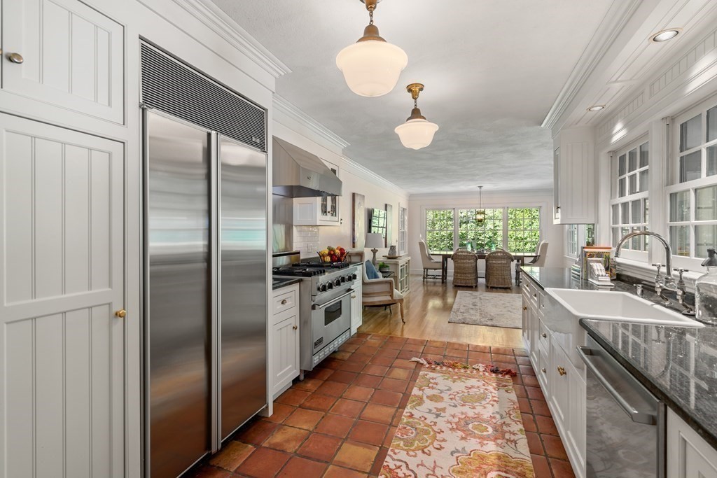 593 Peakham Road Sudbury, MA 01776 - Photo 15 of 42 a large kitchen with kitchen island a large counter space a sink stainless steel appliances and cabinets