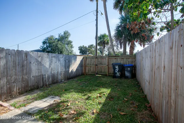 a view of a backyard with wooden fence