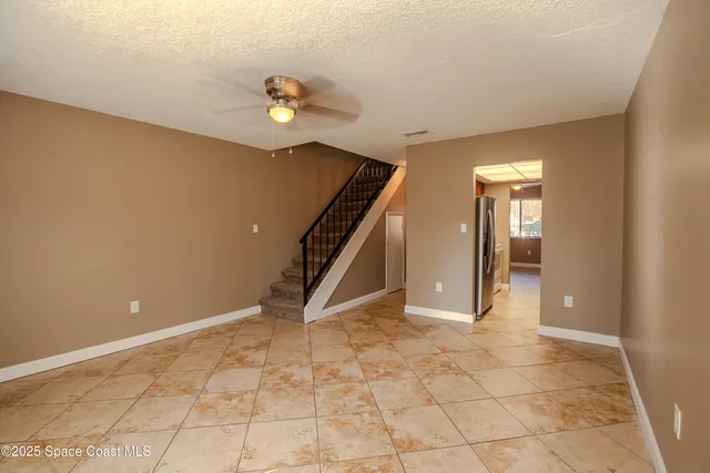 a view of an empty room with stairs and ventilation