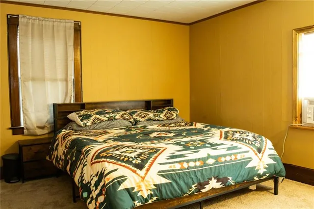 a bed sitting in a bedroom next to a window