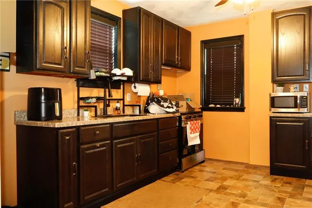 a kitchen with stainless steel appliances granite countertop a stove a sink and a microwave