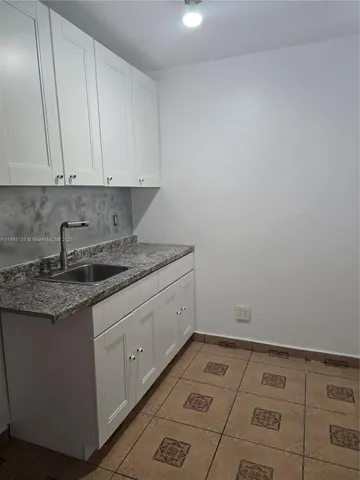 a view of a kitchen with white cabinets
