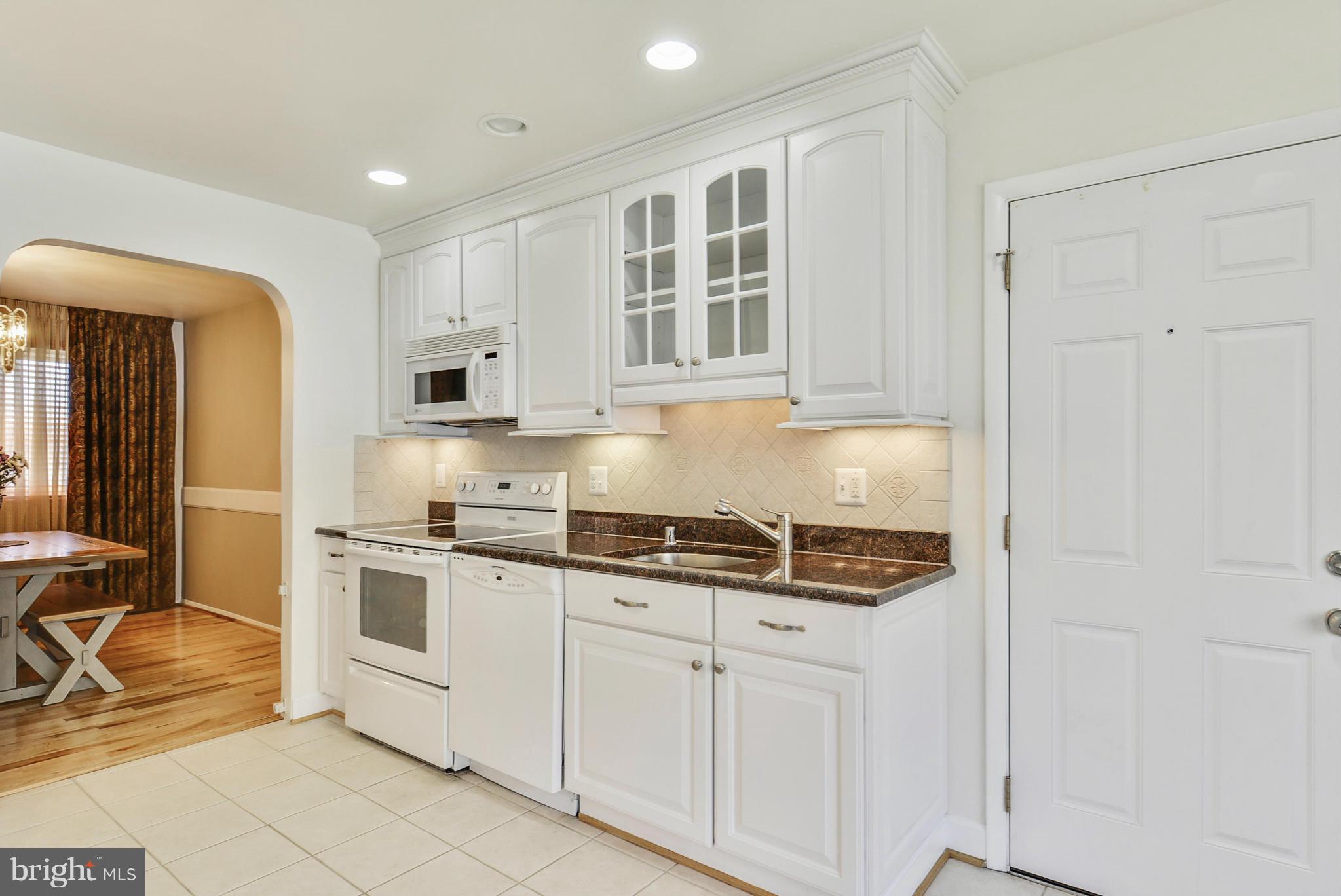 617 Windmill Lane Silver Spring, MD 20905 - Photo 3 of 20 a kitchen with stainless steel appliances granite countertop a stove and white cabinets