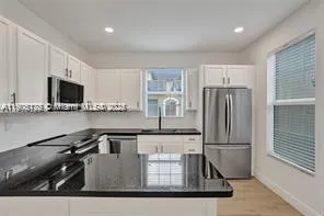 a kitchen with kitchen island a sink appliances and cabinets