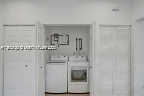 a utility room with cabinets washer and dryer