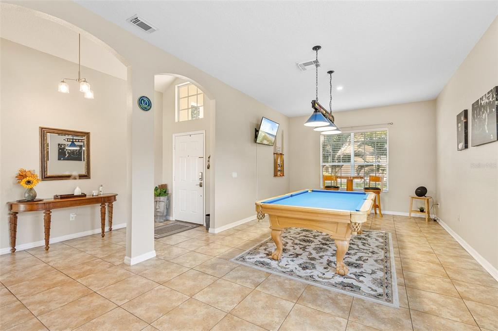 717 Strihal Loop Oakland, FL 34787 - Photo 3 of 32 a dining room with wooden floor a chandelier a wooden table and chairs
