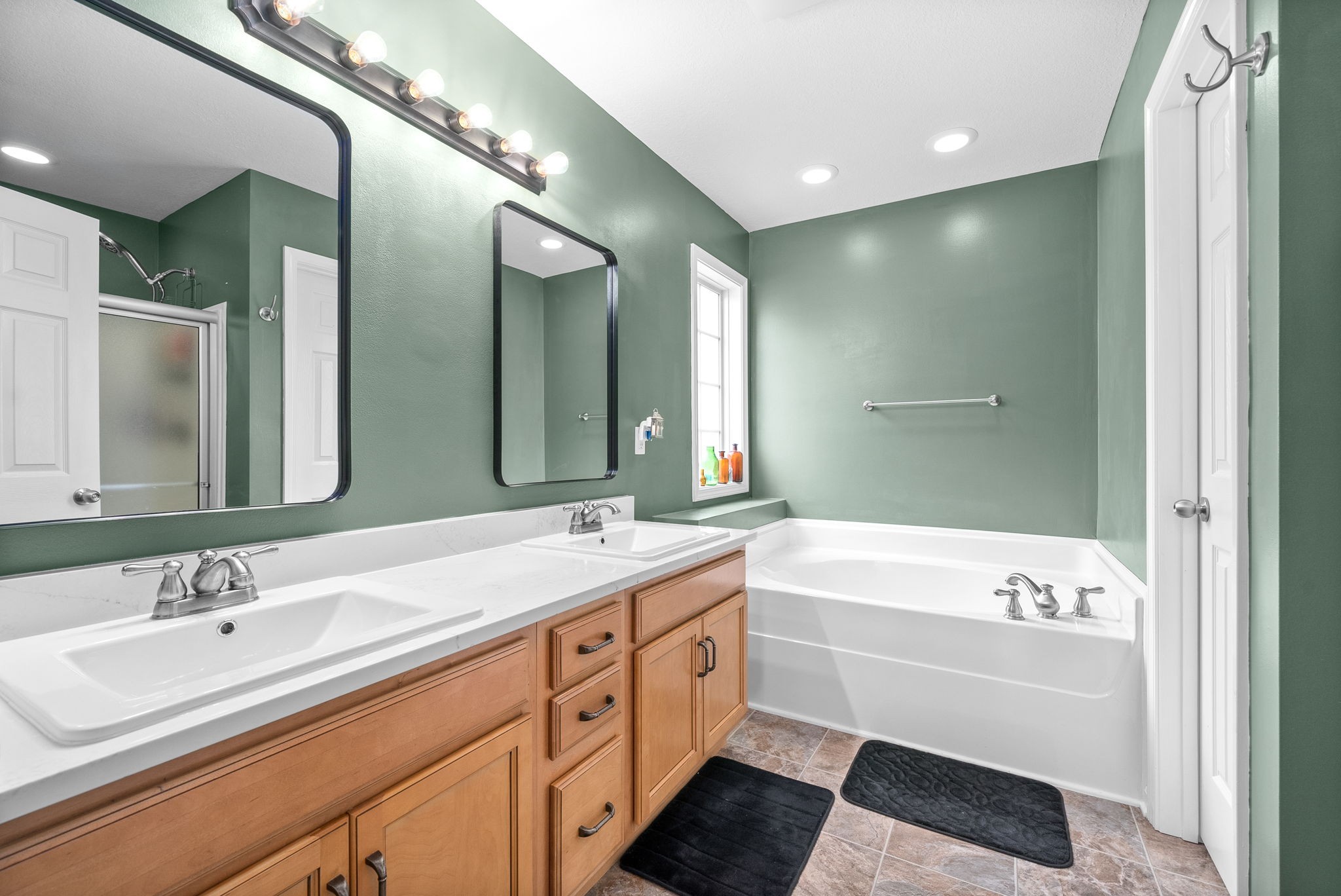 1221 Olive Branch Road Clarksville, TN 37042 - Photo 19 of 36 a bathroom with a double vanity sink a large mirror and a bathtub