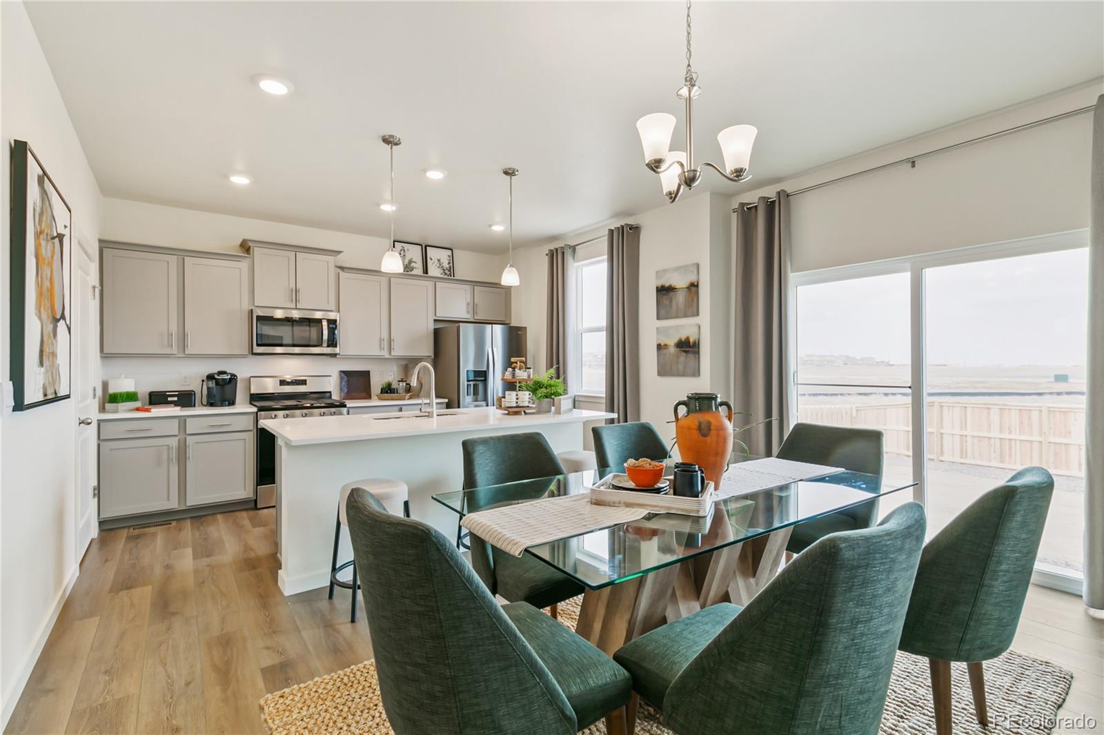 9935 Ceylon Court Commerce City, CO 80022 - Photo 6 of 44 a living room with stainless steel appliances granite countertop furniture a rug kitchen view and a chandelier