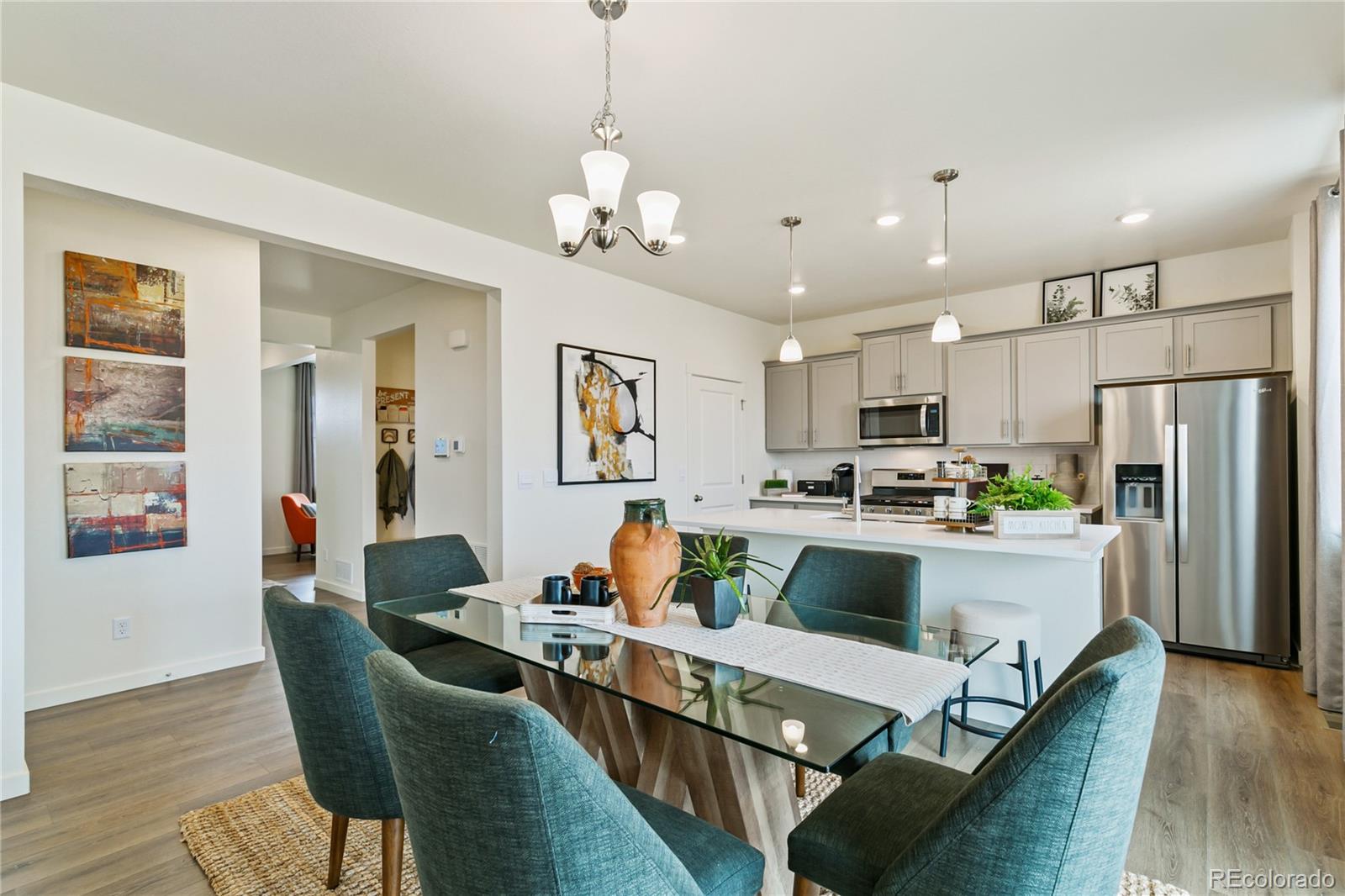 9935 Ceylon Court Commerce City, CO 80022 - Photo 7 of 44 a kitchen with a dining table chairs refrigerator and cabinets