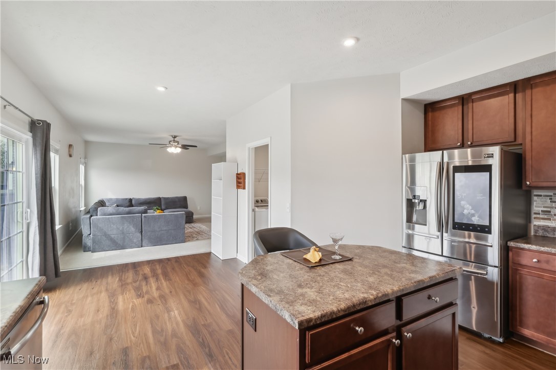 257 Stone Ridge Way Berea, OH 44017 - Photo 20 of 20 Kitchen featuring a kitchen island, stainless steel fridge with ice dispenser, open floor plan, a ceiling fan, and dark wood-style flooring