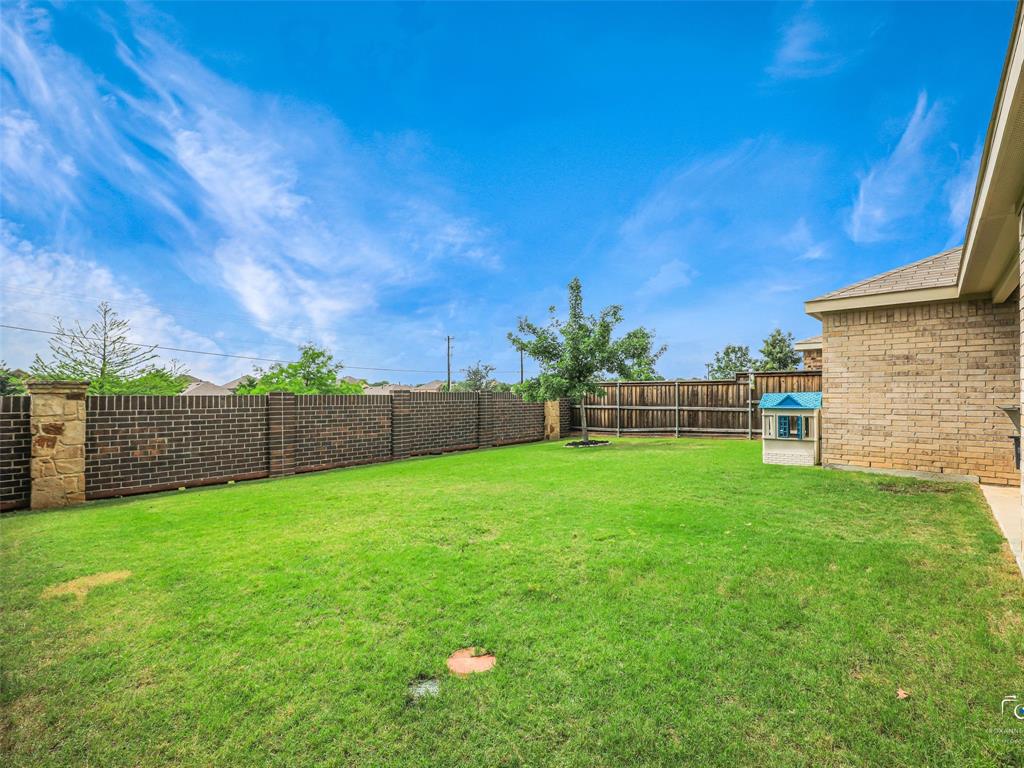 4517 Ashmark Road Aubrey, TX 76227 - Photo 24 of 26 a view of a backyard with potted plants and wooden fence