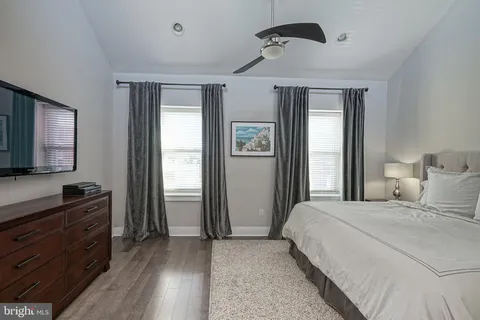 a bedroom with a bed and a flat tv screen on dresser