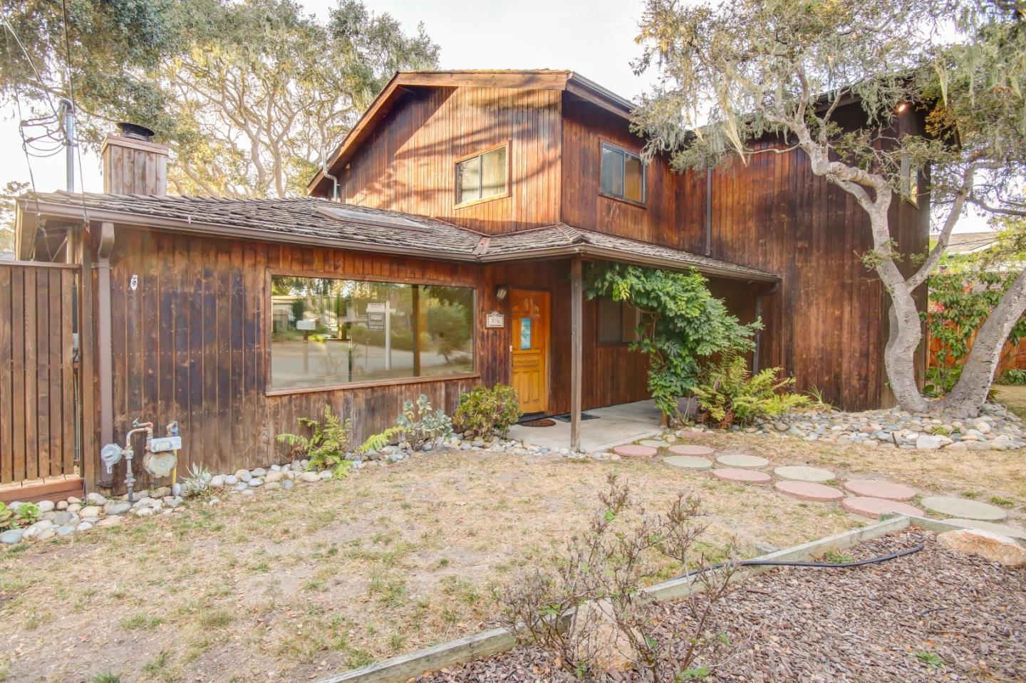 816 Gate Street Pacific Grove, CA 93950 - Photo 1 of 18 a backyard of a house with large tree and wooden fence
