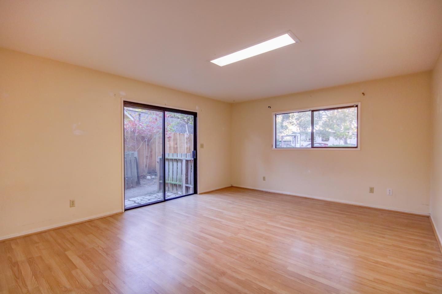 816 Gate Street Pacific Grove, CA 93950 - Photo 11 of 18 a view of an empty room with wooden floor and a window