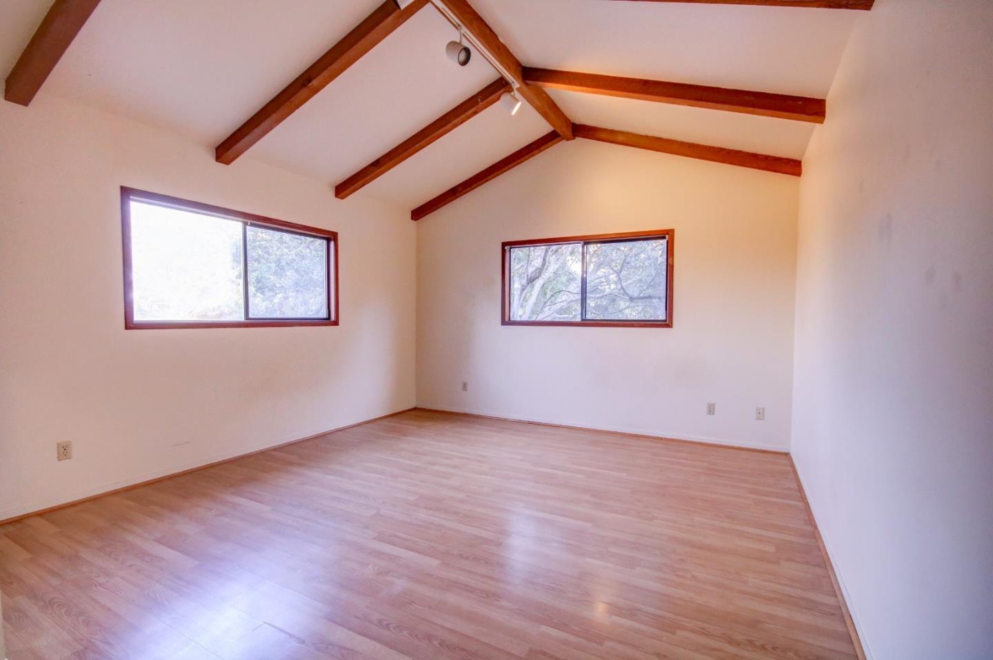 816 Gate Street Pacific Grove, CA 93950 - Photo 12 of 18 a view of an empty room with wooden floor and a window