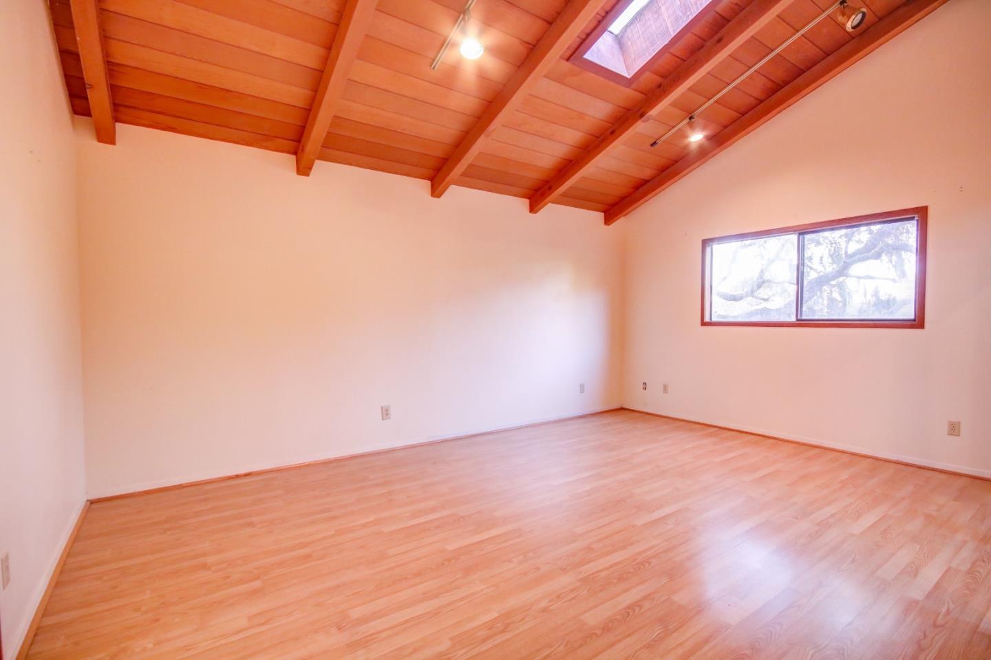 816 Gate Street Pacific Grove, CA 93950 - Photo 14 of 18 an empty room with wooden floor and windows