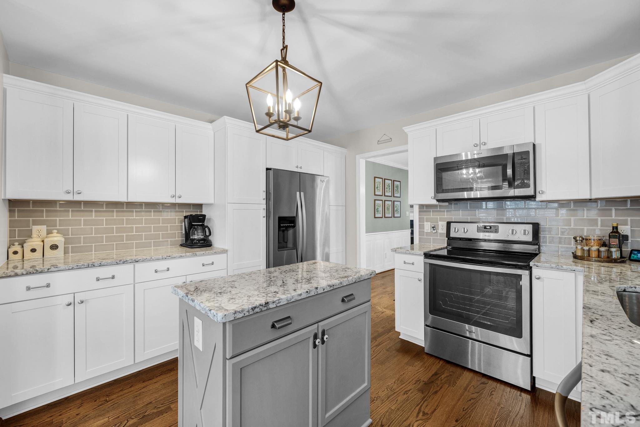 5308 Denmead Way Raleigh, NC 27613 - Photo 20 of 42 a kitchen with granite countertop stainless steel appliances a stove cabinets and wooden floor