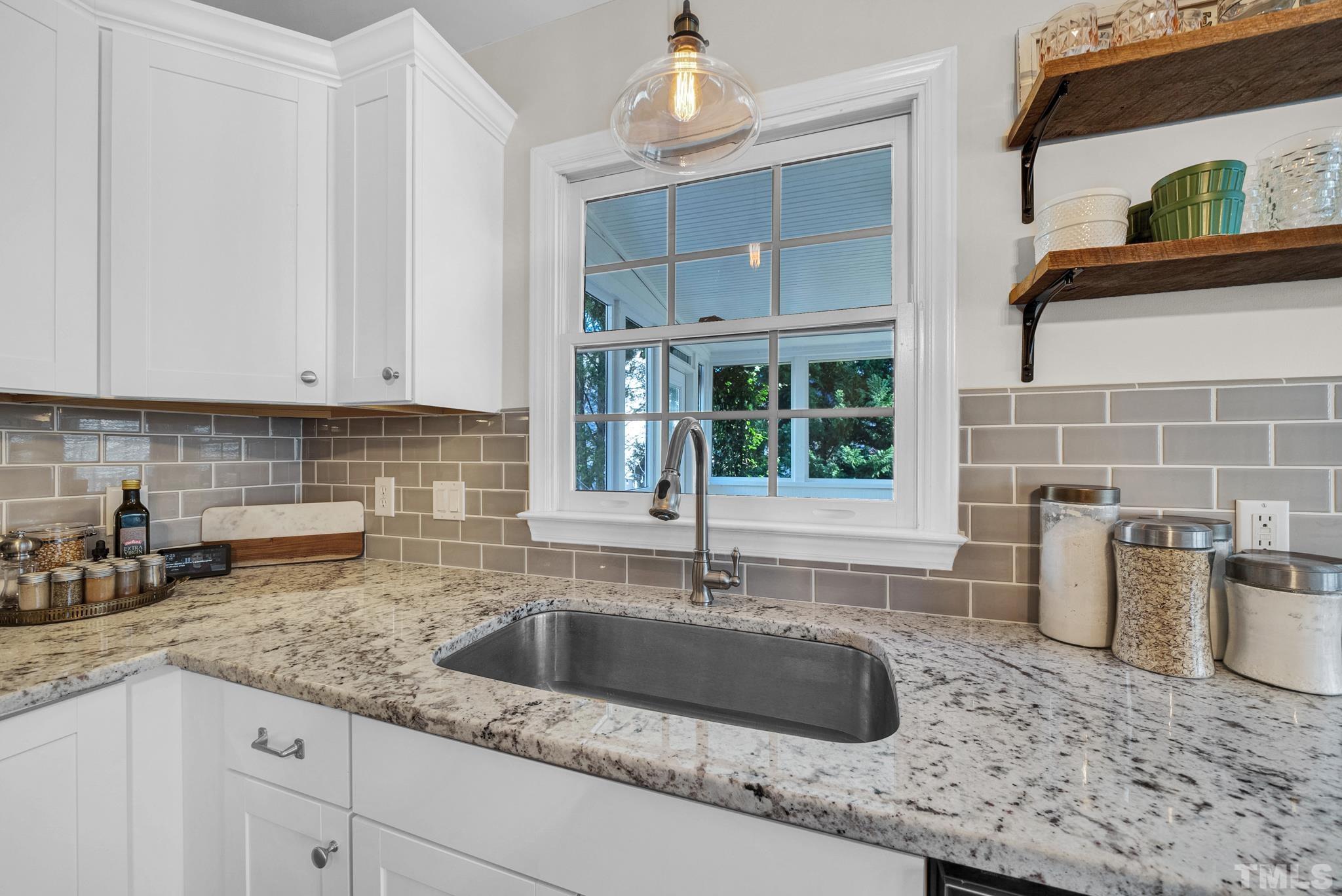 5308 Denmead Way Raleigh, NC 27613 - Photo 22 of 42 a kitchen with granite countertop a sink a stove and cabinets