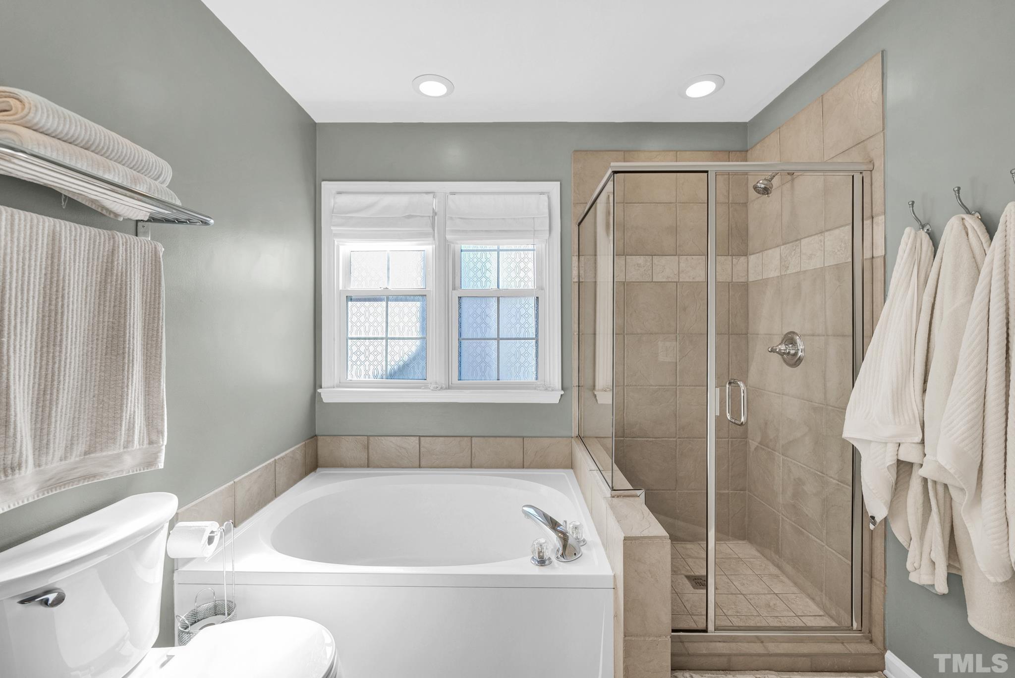 5308 Denmead Way Raleigh, NC 27613 - Photo 30 of 42 a bath tub sitting next to a white toilet and a shower