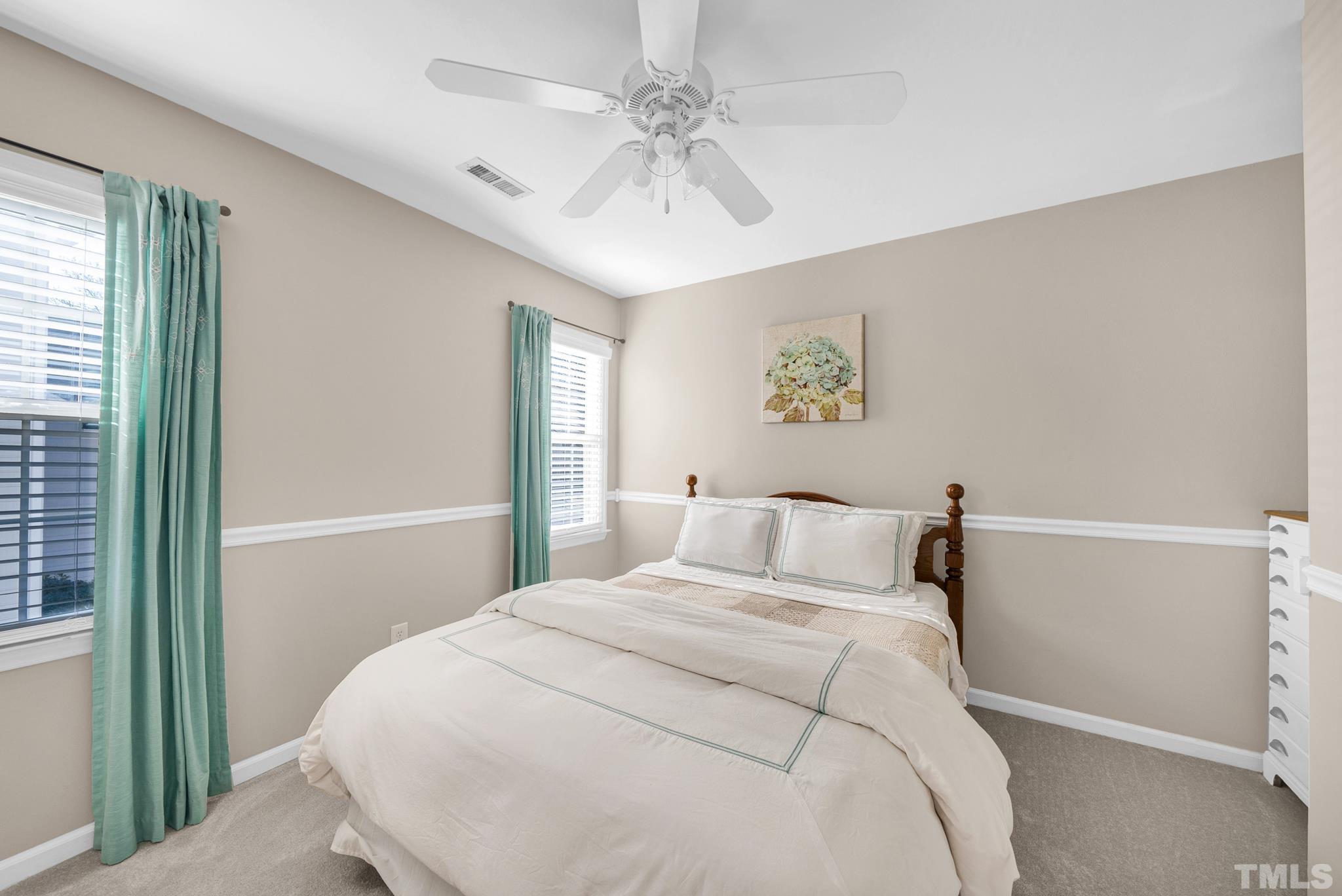 5308 Denmead Way Raleigh, NC 27613 - Photo 33 of 42 a bedroom with a large bed and a chandelier