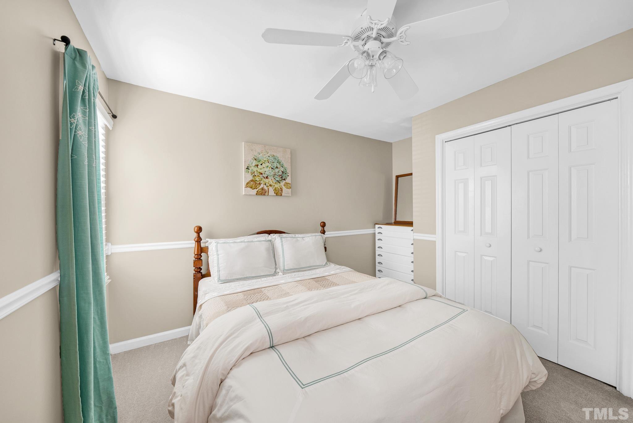 5308 Denmead Way Raleigh, NC 27613 - Photo 34 of 42 a bedroom with a large bed and a chandelier
