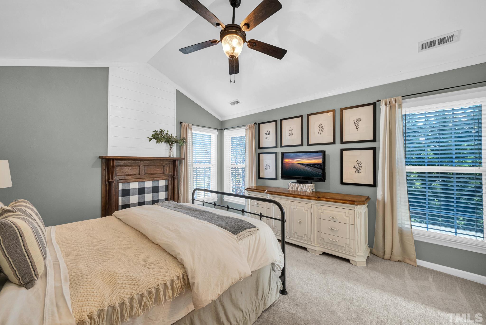 5308 Denmead Way Raleigh, NC 27613 - Photo 6 of 42 a bedroom with a bed a ceiling fan and a flat tv screen