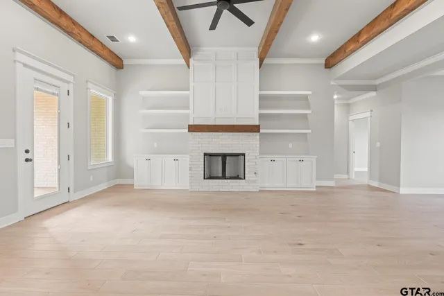 a view of empty room with wooden floor and fireplace