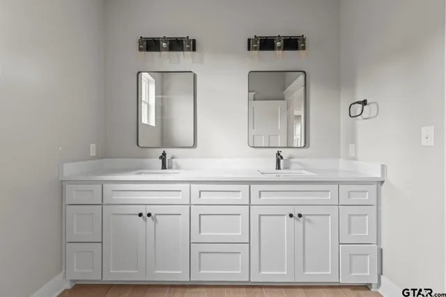 a bathroom with double sink and a mirror