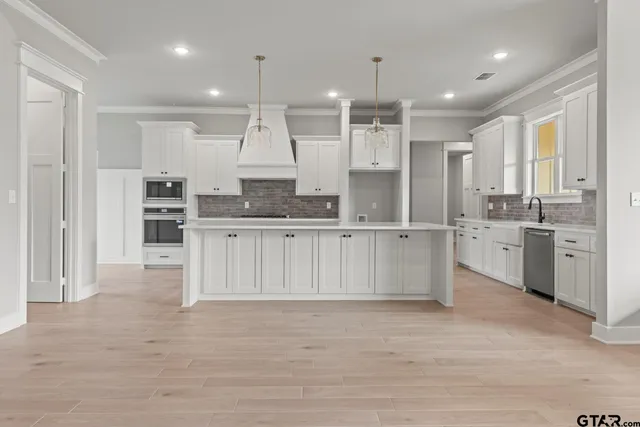 a large white kitchen with a large window