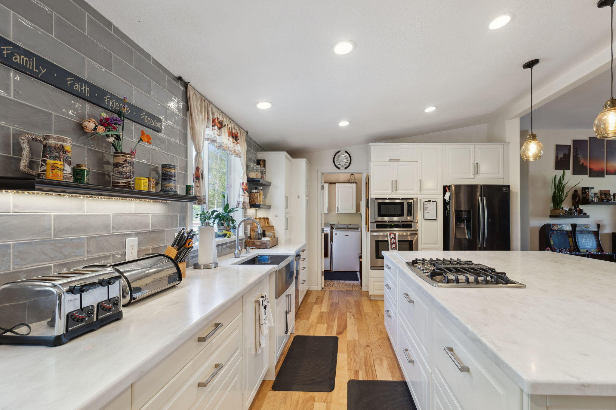 3798 Leonard Road Grants Pass, OR 97527 - Photo 7 of 62 a large kitchen with stainless steel appliances a stove a sink dishwasher a refrigerator and white cabinets with wooden floor