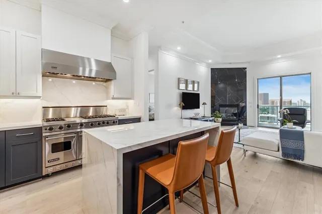 a kitchen with stainless steel appliances granite countertop a stove a sink a refrigerator and a dining table